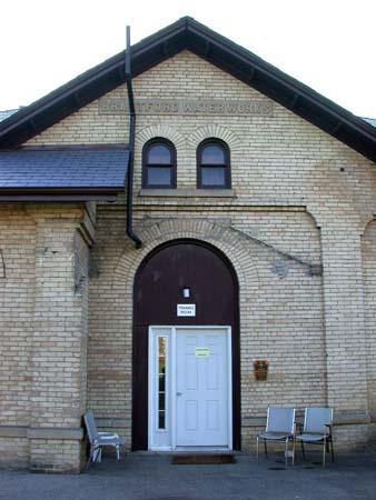 Façade with centre gable and round headed arch over entrance opening with brick voussoirs, 2002.; City of Brantford, Department of Planning, 2002.