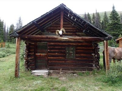 View of the main entrance to the Divide Warden Cabin, showing the off-centered entrance porch, 2016.; Steve Malins, Agence Parcs Canada / Parks Canada Agency, 2016.
