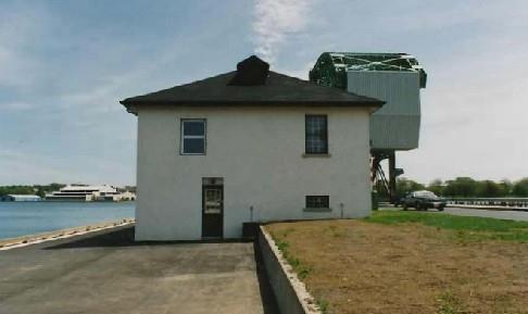 Side view of the Bridge Office and Shop, showing the slightly recessed windows and stone window sills, 1993.; Department of Public Works / Ministère des Travaux publics, 1993.