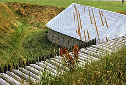 View of east façade of the Caponier, showing the massive masonry walls, evenly coursed at the exterior face, 1980.; Parks Canada Agency / Agence Parks Canada, K. Darowski, 1980
