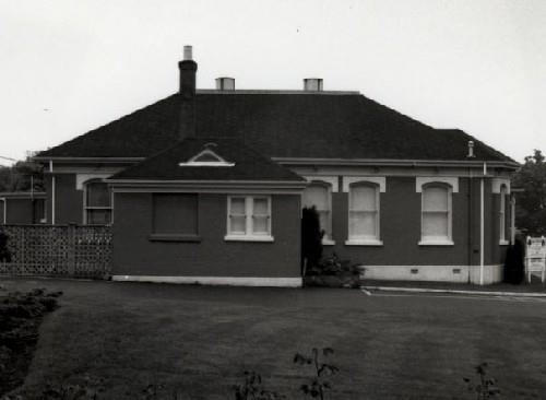 Side view of Building 20, showing the low massing of the one-storey, rectangular, hipped-roofed brick building, 1989.; Parks Canada Agency / Agence Parcs Canada, 1989.