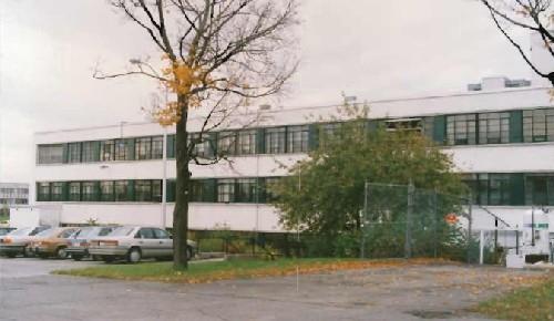 General view of Building M-12, showing the reinforced concrete construction and white stucco clad exterior walls, 1990.; National Research Council Canada / Conseil national de recherches du Canada, 1990.