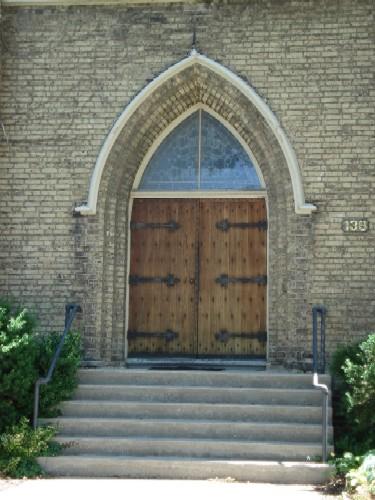 Featured is the double wooden doorway topped by arched gothic transom on the façade.; Kendra Green, 2007