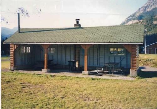 View of Kitchen Shelter 13, showing its simple, low massing of the one-storey, three-sided structure, 1990.; Agence Parcs Canada / Parks Canada Agency, 1990.