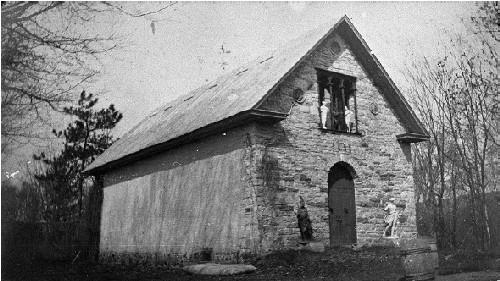 View of the Family Museum, showing the denuded appearance of the exterior, with walls constructed of plain stone and brick  without any openings other than those of the main façade, circa 1915.; Agence Parcs Canada / Parks Canada Agency, vers / circa 1915.