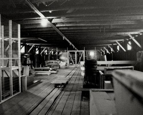 View of the Northern Commercial Company Warehouse, showing the interior central tramway feature to facilitate the storage and retrieval of goods in the warehouse, 1987.; Agence Parcs Canada / Parks Canada Agency, 1987.