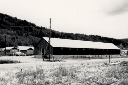 View the Northern Commercial Company Warehouse, showing the numerous small windows, placed at regular intervals on the long walls  and immediately under the top plate, 1987.; Agence Parcs Canada / Parks Canada Agency, 1987.