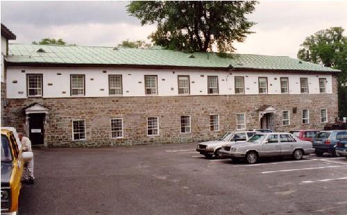 View of Building 1, showing the ground floor’s solid masonry construction and the stucco finish of the upper storey, 1993.; Agence Parcs Canada / Parks Canada Agency, 1993.