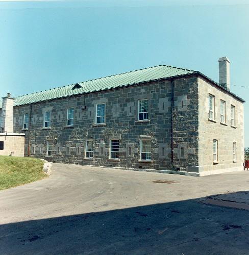 View of Building 2, showing the sturdy long, two-storey, rectangular massing with a hipped roof clad in copper, circa 1980.; Ministère de la Défense nationale / Department of National Defence, vers / circa 1980.
