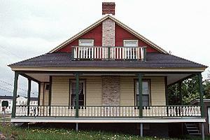 Side view of Building 34, showing the clapboard clad exterior and the chimneystack, circa 2004.; Parks Canada Agency / Agence Parcs Canada, circa / vers 2004.