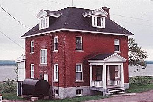 View of Building 77, showing the two-and-a-half-storey, cubic-shaped massing with truncated hipped roof, circa 2004.; Agence Parcs Canada / Parks Canada Agency, circa / vers 2004.