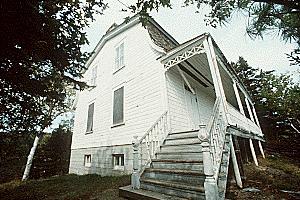 Corner view of Building 43, showing the steps and the covered verandah with turned posts, circa 2004.; Parks Canada Agency / Agence Parcs Canada, circa / vers 2004.