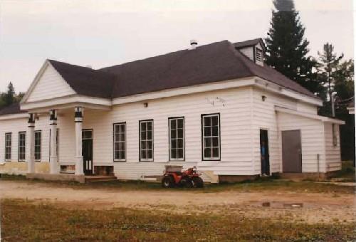 General view of the Main Hatchery Building, showing the horizontal wood siding of the exterior walls and the black and white exterior trim, 1993.; Parks Canada Agency / Agence Parcs Canada, 1993