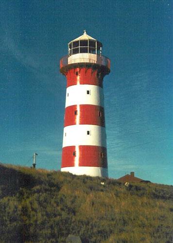 View of the Cape Pine Lighthouse, showing the smooth, painted finish of the exterior walls with its distinguishing colour scheme of alternating white and red, 1990.; Agence Parcs Canada / Parks Canada Agency, 1990.