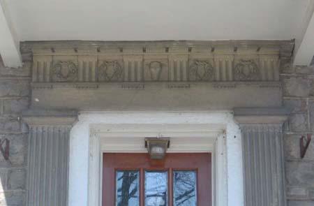 Fluted pilasters and decorated pediment displaying carved wreaths and a central lamb's head.; Lindsay Benjamin, 2007.