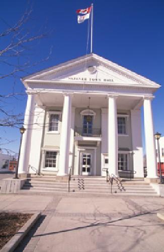 View of Napanee Town Hall, showing its two-storey, gable-roofed massing with a monumental pedimented portico with giant free-standing columns approached up broad steps, 1995.; Agence Parcs Canada / Parks Canada Agency, 1995.