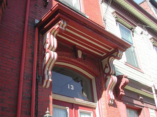 This photograph shows the ornate brackets that support the entablature over the entrance, 2005; City of Saint John