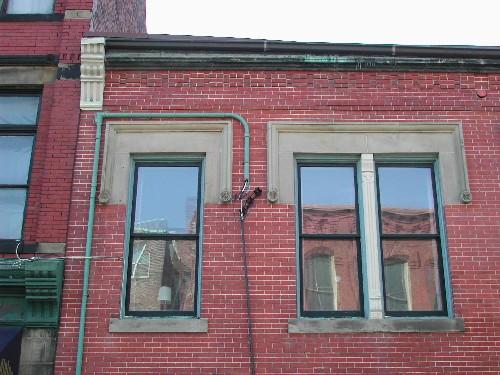 This photograph shows the upper floor windows and the square hood moulding lintels, 2005 ; City of Saint John