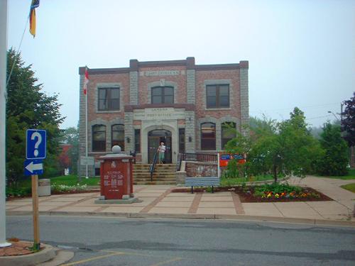 This image shows a contextual view of the building, including the plaza, 2008; Province of New Brunswick