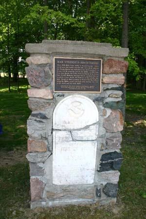 Plaque commemorating the first black settlement and the only original stone from the cemetery.; Ministry of Culture, 2007.