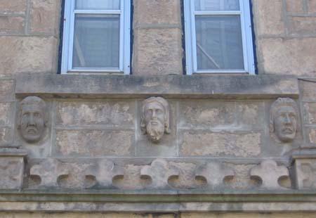 Detailed view of three of the carved stone heads found on the front (northeast) gable-end.; Lindsay Benjamin, 2007.