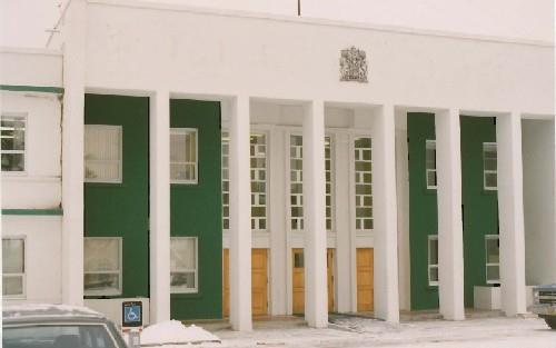 View of the main entrance to Building 200, showing the distinctive, raised central entrance portico with large freestanding columns, 1991.; Public Works and Government Services Canada / Travaux publics et Services gouvernementaux Canada, 1991.