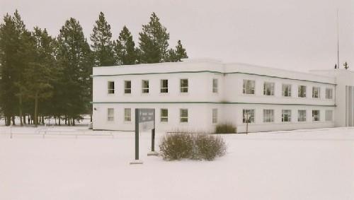 Corner view of Building 200, showing the evenly spaced, long rectangular windows of the wings and narrow rectangular windows of the recessed ends, 1991.; Public Works and Government Services Canada / Travaux publics et Services gouvernementaux Canada, 1991.