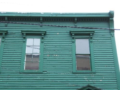 This photograph shows the upper storey windows as well as the roof-line cornice decorated with dentils and brackets, 2005; City of Saint John