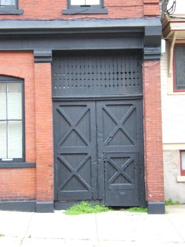 This photograph shows the old wooden shop door and brick pilasters, 2005; City of Saint John