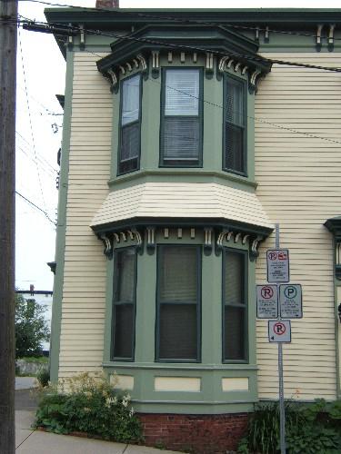 This photograph shows the semi-octagonal bay window, with brackets under each storey's cornice, 2005; City of Saint John