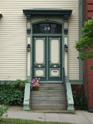 This photograph shows the elevated entrance with transom window and bracketed entablature, 2005; City of Saint John