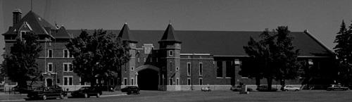 Front view of the Salaberry Armoury, showing the building’s two and three storey massing, the stepped profile, monumental scale and proportions, 1898.; Parks Canada Agency / Agence Parcs Canada, Henri Langlois, 1989.