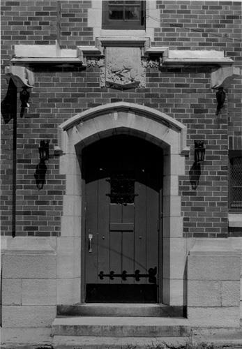 General view of the Salaberry Armoury, showing a concentric Tudor entrance arch and carved plaque, 1989.; Parks Canada Agency / Agence Parcs Canada, Henri Langlois, 1989.