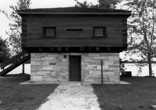 Façade of the Blockhouse, showing the ground floor of stone masonry and the timber framed upper storey of squared timber, 1989.; Department of Public Works / Ministère des Travaux publics, 1989.