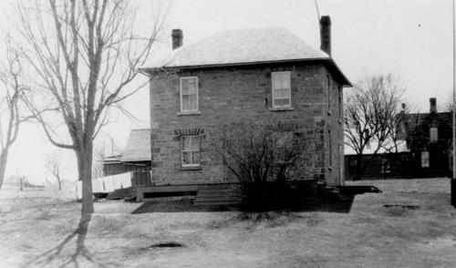 View of the eastern façade of the Defensible Lockmaster's House, showing the symmetrical placement of the second-storey windows, 1930.; Parks Canada Agency / Agence Parcs Canada, 1930