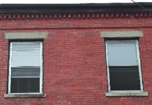 This photograph shows the dentils at the roof-line cornice and the two upper storey windows, 2005; City of Saint John
