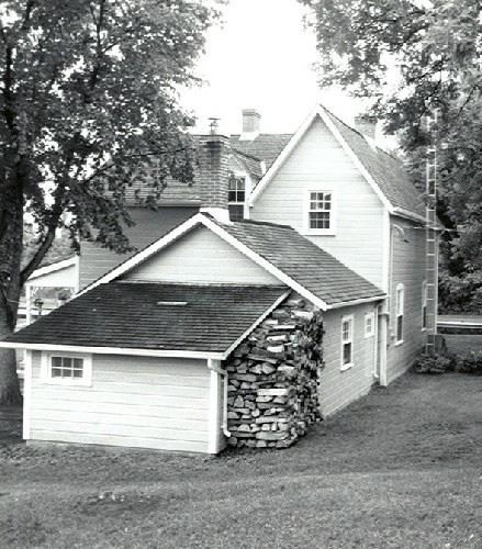 Rear view of the Lockmaster's House, showing the gabled roof and the chimney, 1989.; Parks Canada Agency / Agence Parcs Canada, Couture, 1989.
