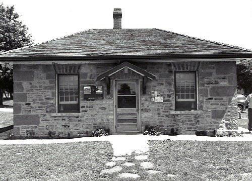 Façade of the Defensible Lockmaster's House, showing the simple compact, one-storey massing, 1989.; Parks Canada Agency / Agence Parcs Canada, Couture, 1989.