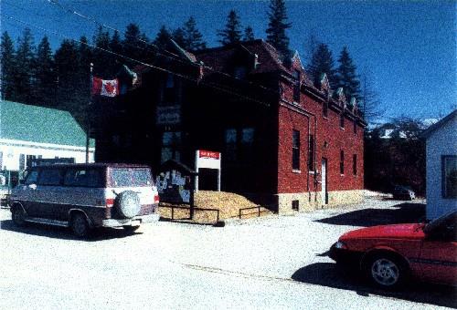 Corner view of the Government of Canada Building in Sherbrooke, showing its modestly detailed brickwork, the concrete foundation and the stone window sills, 1998.; Parks Canada Agency / Agence Parcs Canada, KAL, 1998.