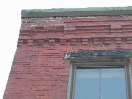 This photograph shows the cornice, with small corbel bands, and illustrates a sandstone lintel, 2005; City of Saint John