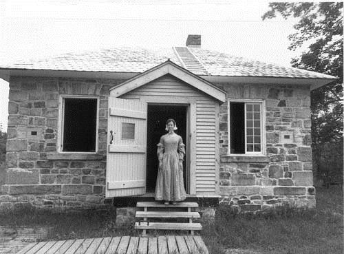 Façade of the Jones Falls Defensible Lockmaster's House, showing the simple, compact, one-storey massing, 1989.; Parks Canada Agency / Agence Parcs Canada, 1989.