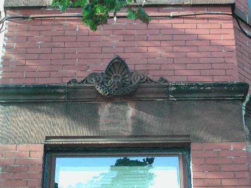 This photograph shows the protruding carving over a lower storey lintel, 2005; City of Saint John