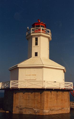 View of the façade of the Tower, showing the decking and framing design around both the base and the lantern, 1987.; Department of Transport / Ministère des Transports, 1987.