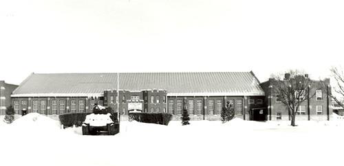View of the main entrance to the D.V. Currie VC Armoury, showing the central entrance for the troops, 1989.; Department of National Defence / Ministère de la Défense nationale, 1989.