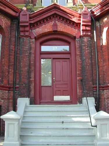 This photograph shows the main entrance in the centre of the front façade with broad pilasters and peaked entablature, 2005; City of Saint John