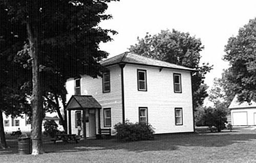 General view of the Defensible Lockmaster's House, showing the symmetries and materials of its principal elevations, 1989.; Parks Canada Agency / Agence Parcs Canada, Couture, 1989.