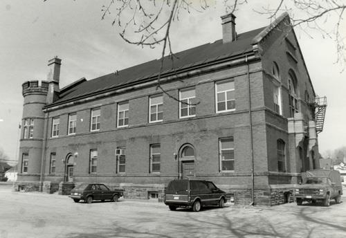 View of the side of the Armoury, showing the large, rectangular massing under a gable roof, 1991.; Department of National Defence / Ministère de la Défense nationale, 1991.