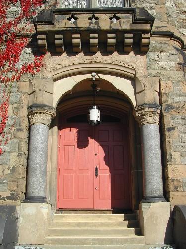 This photograph shows the wide entrance with large columns and second storey balustrade with large stone modillions, 2005; City of Saint John