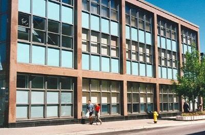 General view of the Government of Canada Building, showing the inset curtain wall of blue spandrel panels and the green tinted glazing, 1996.; Parks Canada Agency | Agence Parcs Canada, 1996.