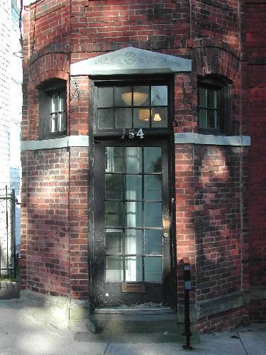 This photograph shows the wood door with glass panels located in one of the bays of the front façade, 2005; City of Saint John